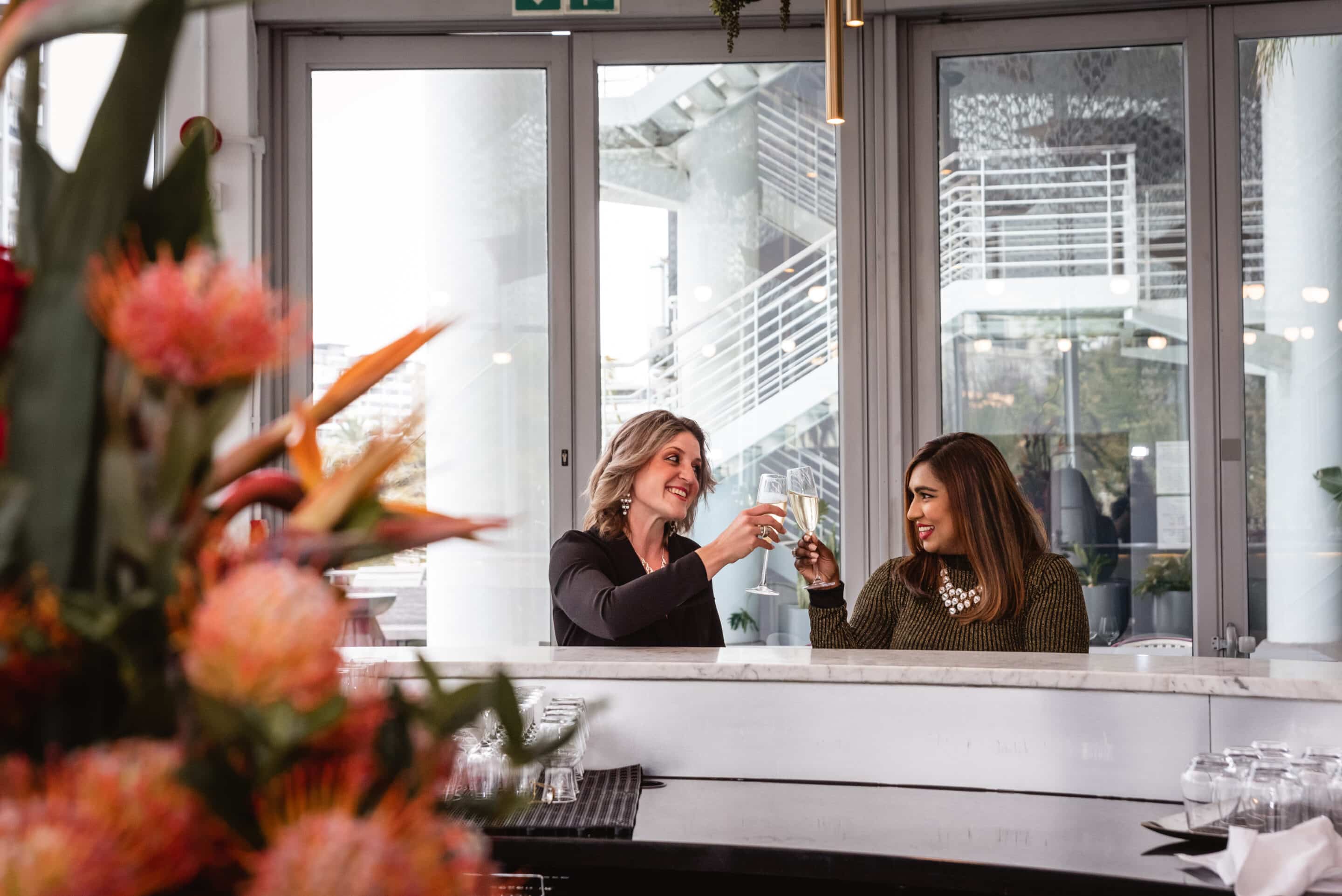 Two women enjoying a glasses of champagne at the bar.