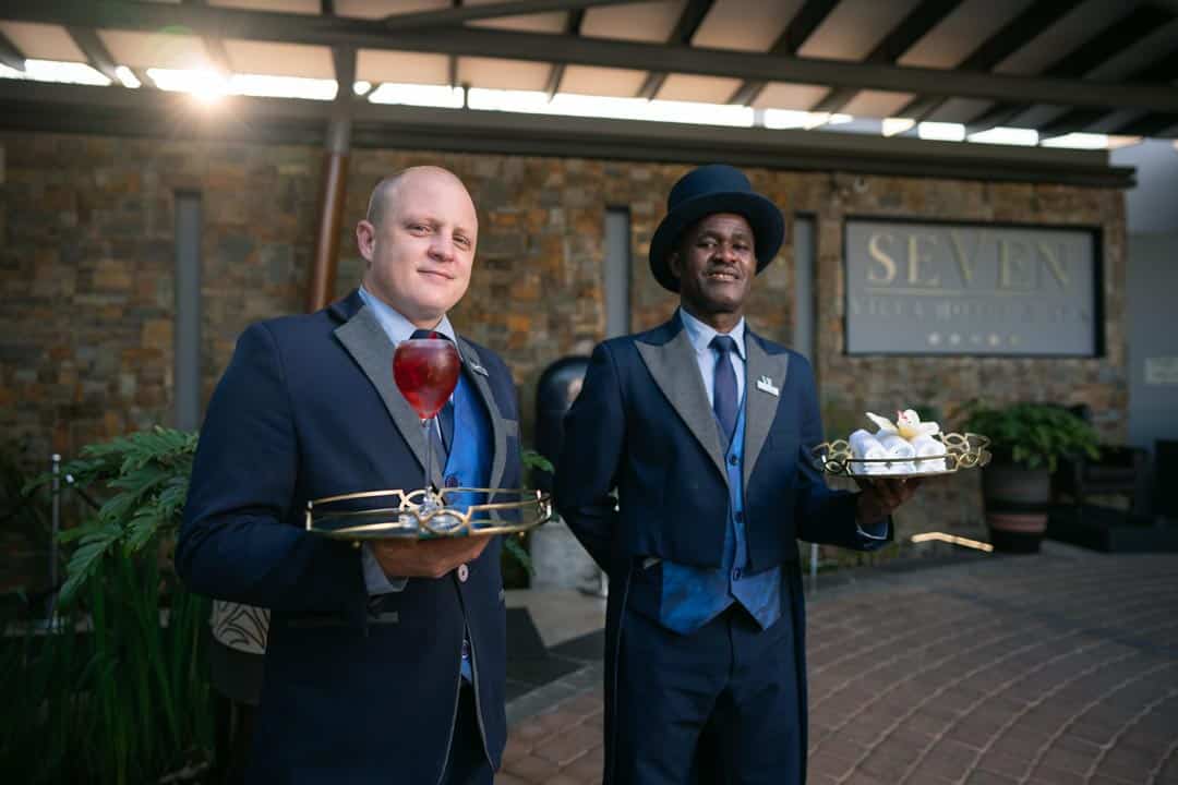 Butlers carrying a wine glass