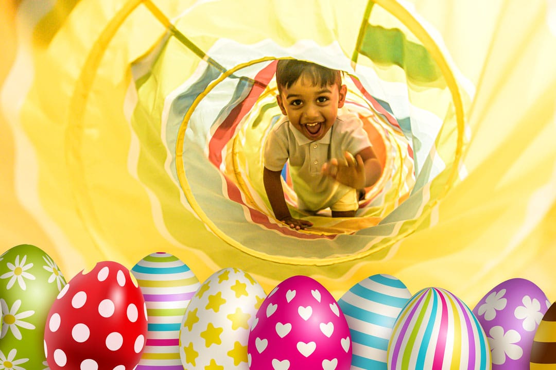 A child crawling through a tunnel to get some easter eggs.