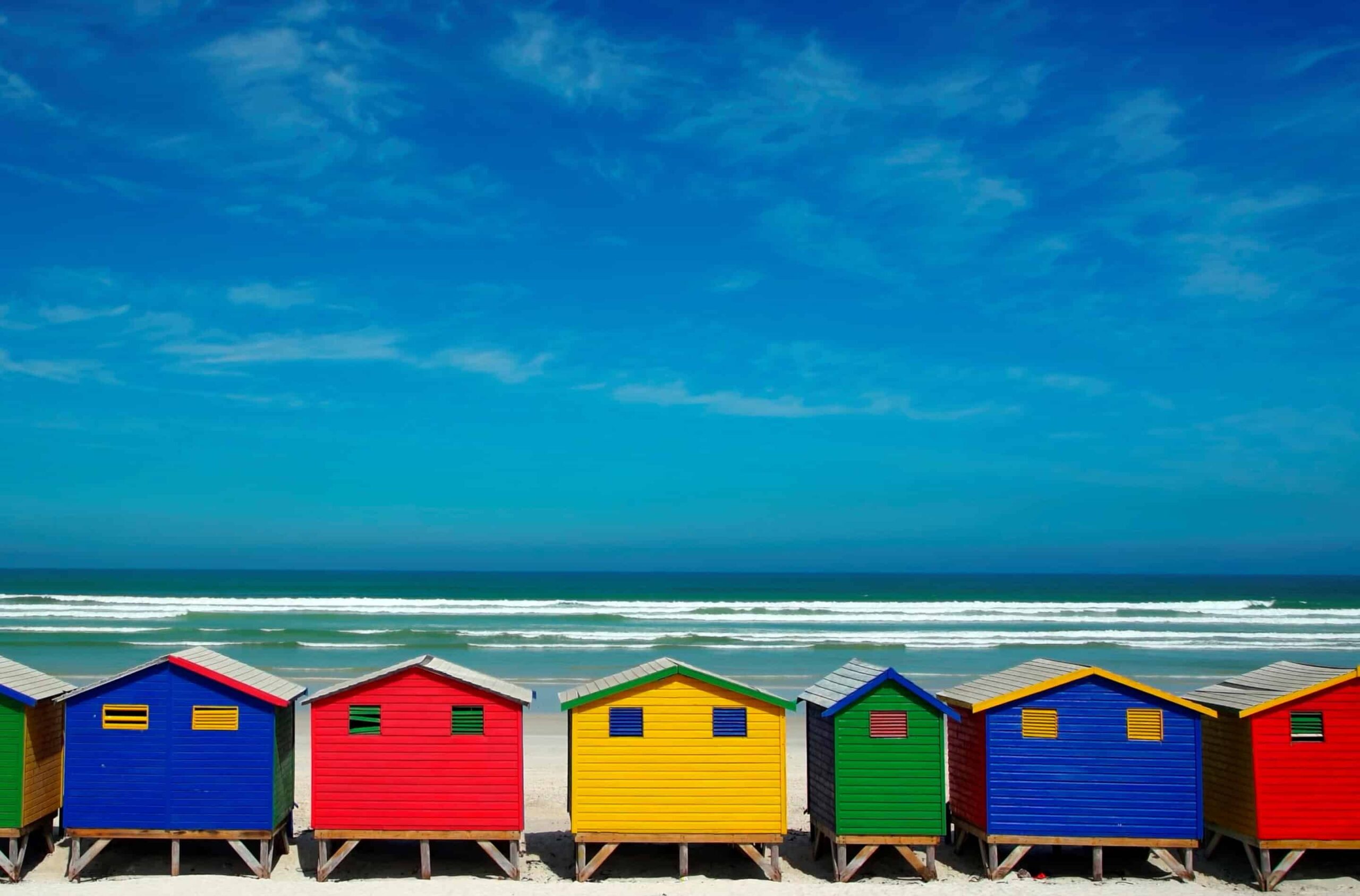Multi-coloured beach houses on the background of the sea des maisons de plage colorées avec la mer en toile de fond.