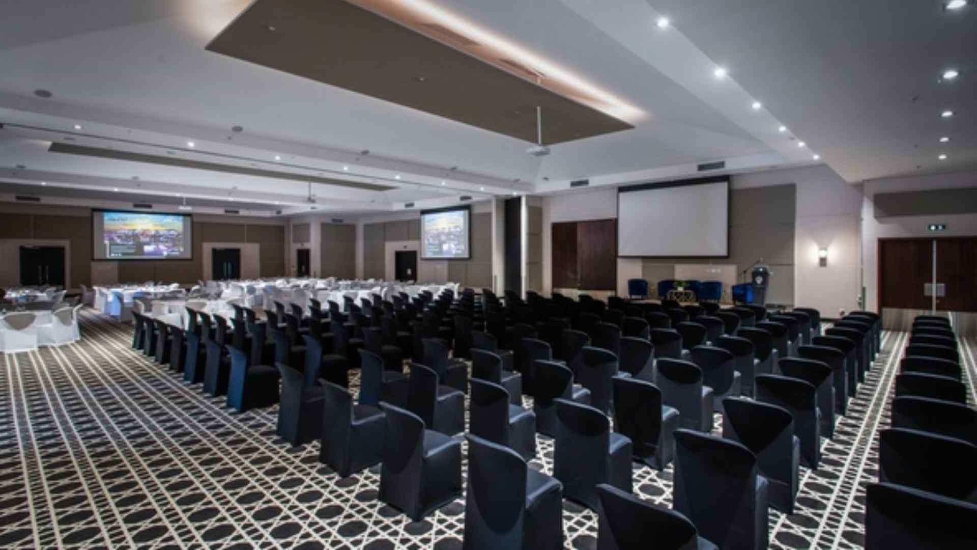 Conference room at The Capital Hotels set up theatre-style with presentation screens