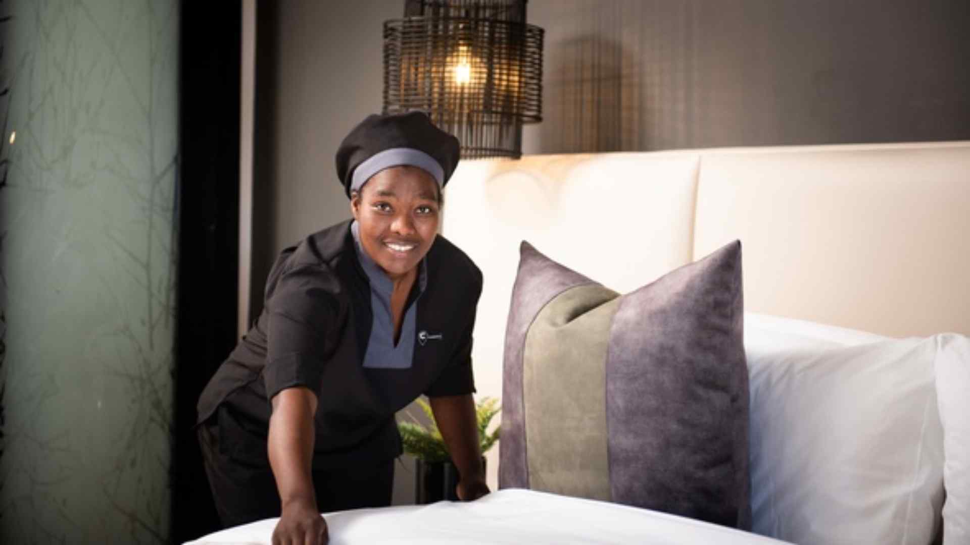 Housekeeper making up a bed with fresh linen