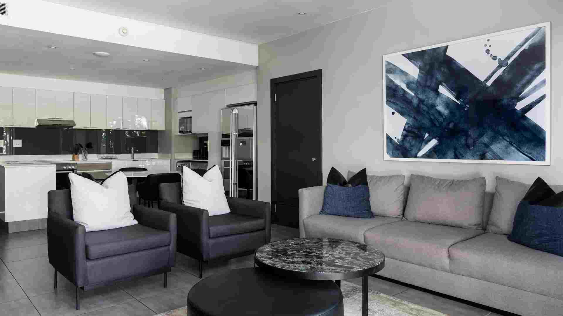 Open-plan hotel apartment with lounge seating and a fully equipped kitchen